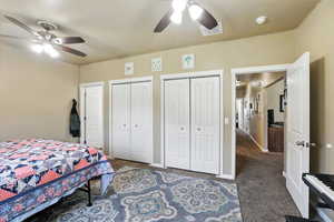 Bedroom featuring carpet floors, two closets, and a ceiling fan