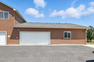 View of side of property with a shingled roof