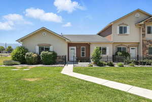 View of front of house with stone siding, stucco siding, and a shingled roof