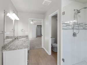 Full bath featuring a shower stall, ceiling fan, and vanity