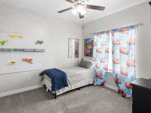 Carpeted bedroom featuring baseboards and a ceiling fan