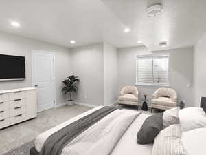 Bedroom with light carpet, recessed lighting, and a textured ceiling