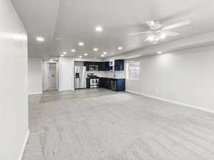 Living room with recessed lighting, light colored carpet, ceiling fan, and a textured ceiling