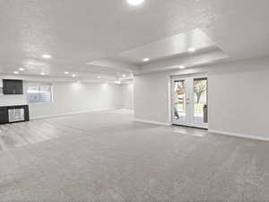 Family room area featuring a textured ceiling, light colored carpet, recessed lighting, french doors, and ceiling fan