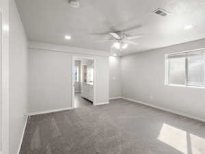Bedroom featuring carpet floors, a textured ceiling, recessed lighting, ensuite bath, and ceiling fan