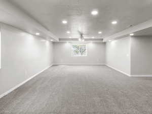 Below grade area featuring recessed lighting, carpet flooring, a textured ceiling, and ceiling fan