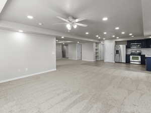 Living room with light colored carpet, recessed lighting, and a ceiling fan