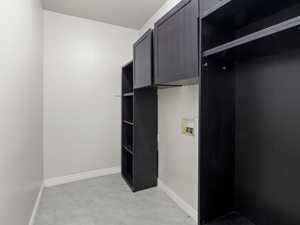 Laundry area with cabinet space, hookup for a washing machine, and light tile patterned flooring
