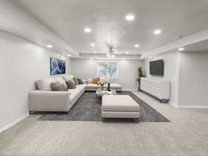 Living room featuring carpet floors, recessed lighting, a ceiling fan, and a textured ceiling