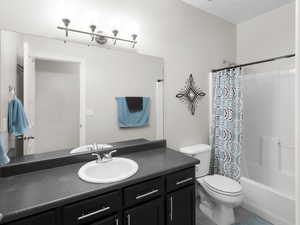 Full bathroom featuring vanity, shower / bath combo with shower curtain, and tile patterned floors