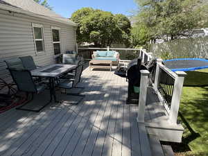 Wooden terrace featuring a water view, outdoor lounge area, and outdoor dining area