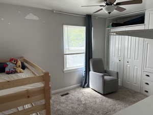Carpeted bedroom with baseboards and a ceiling fan