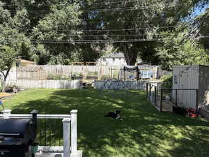 Fenced backyard with a greenhouse and an outdoor structure