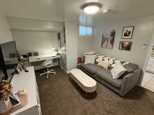 Living room with carpet floors and an office area