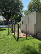 View of yard featuring a trampoline and an outbuilding