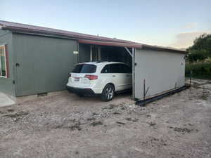 View of property exterior with an attached carport and a metal roof