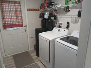 Laundry room featuring independent washer and dryer and light wood-type flooring