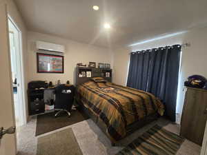 Bedroom featuring carpet flooring and a wall unit AC