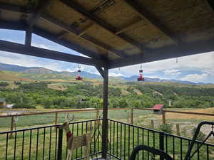 Deck featuring a rural view, a mountain view, and an outdoor structure