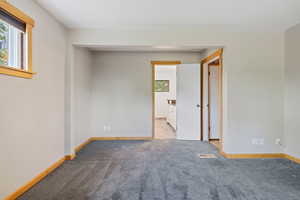 Carpeted empty room with baseboards