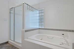 Full bath featuring a shower stall and a jetted tub