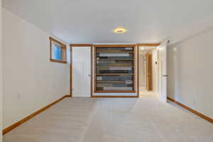 Empty room with baseboards and light carpet