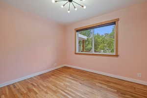 Empty room featuring a chandelier and light wood-style flooring