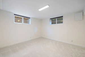 Basement featuring light carpet and baseboards