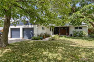 Ranch-style house with a garage, a front yard, concrete driveway, and brick siding