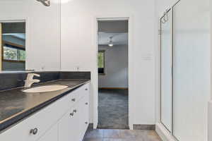 Bathroom with vanity, a stall shower, and tile patterned floors