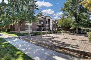 View of front of house with brick siding and volleyball court
