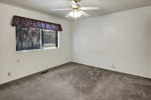Empty room featuring carpet floors and ceiling fan