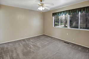Spare room featuring carpet flooring and ceiling fan