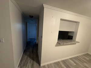 Hall featuring wood finished floors and ornamental molding