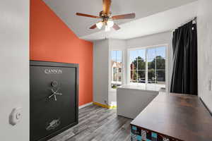 Office space featuring wood finished floors, a ceiling fan, and vaulted ceiling