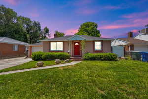 Ranch-style house featuring brick siding, a chimney, concrete driveway, and an attached garage.
