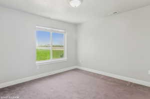 Carpeted empty room featuring baseboards
