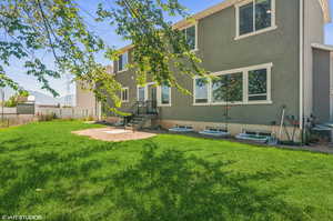 Rear view of property featuring stucco siding and a patio area