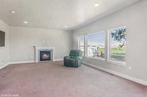 Main floor family room with a glass-covered fireplace, carpet flooring, and recessed lighting