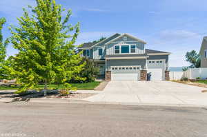 Craftsman-style home with stone siding, board and batten siding, an attached garage, and driveway
