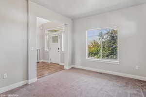 Carpeted spare room with baseboards