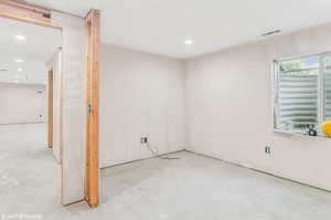 Empty room with concrete flooring and recessed lighting