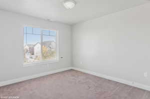 Carpeted spare room with baseboards