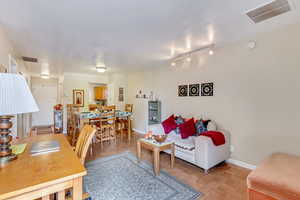 Living area featuring baseboards and track lighting