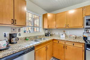 Kitchen featuring stainless steel appliances and light stone counters