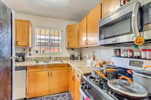 Kitchen with appliances with stainless steel finishes and a sink