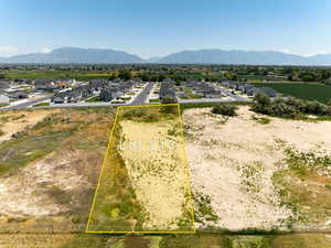 Aerial view of residential area with a mountain backdrop and property parcel outlined