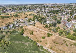 Aerial view of property and surrounding area with nearby suburban area