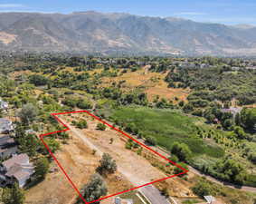 Aerial view of property and surrounding area featuring property boundaries highlighted and a mountain backdrop