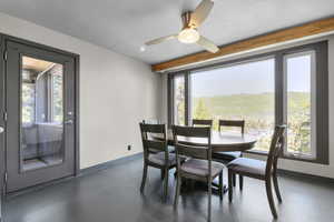 Dining room featuring finished concrete flooring, healthy amount of natural light, a ceiling fan, and recessed lighting
